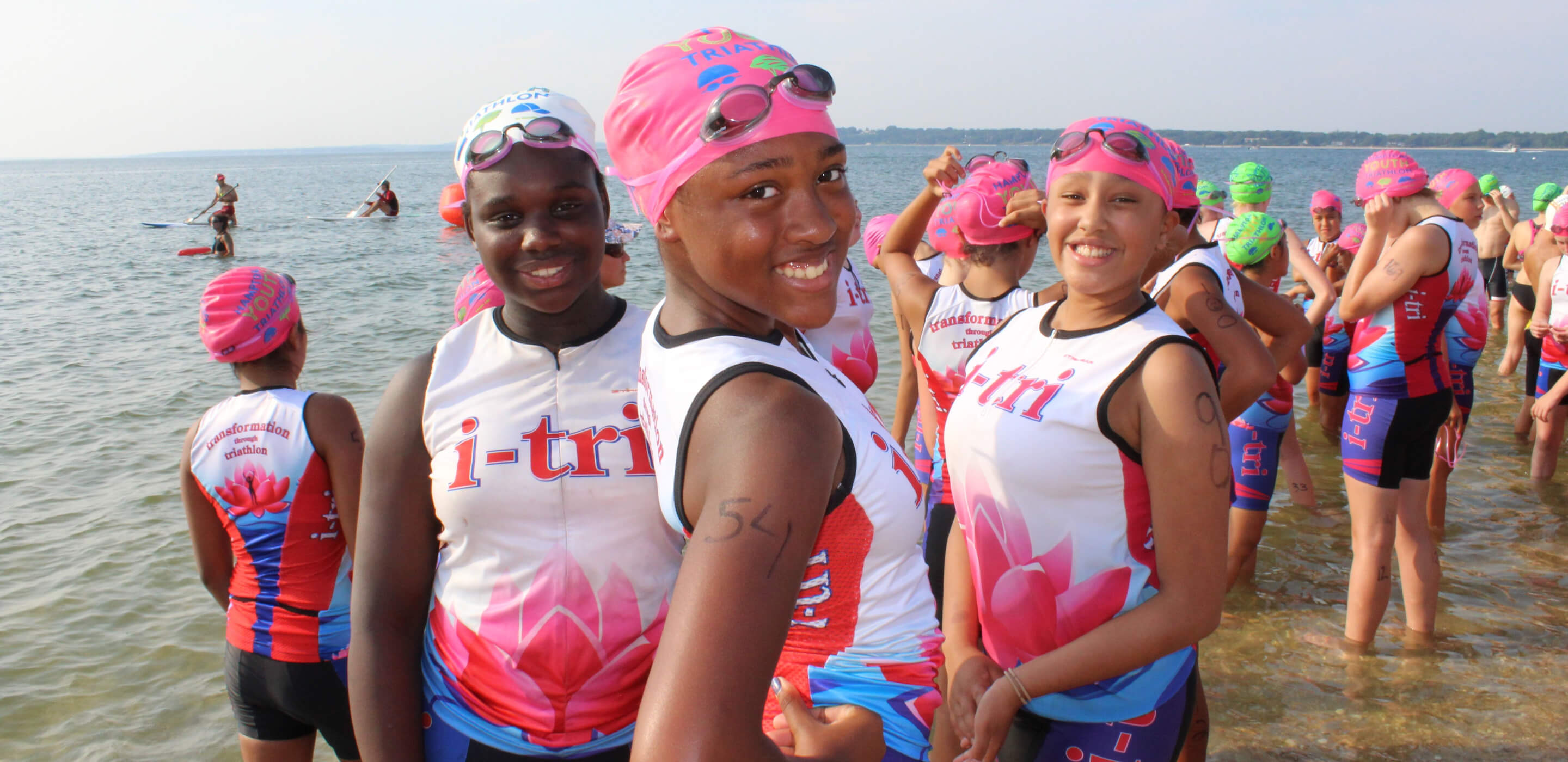 Swimmers in i-tri uniforms on beach